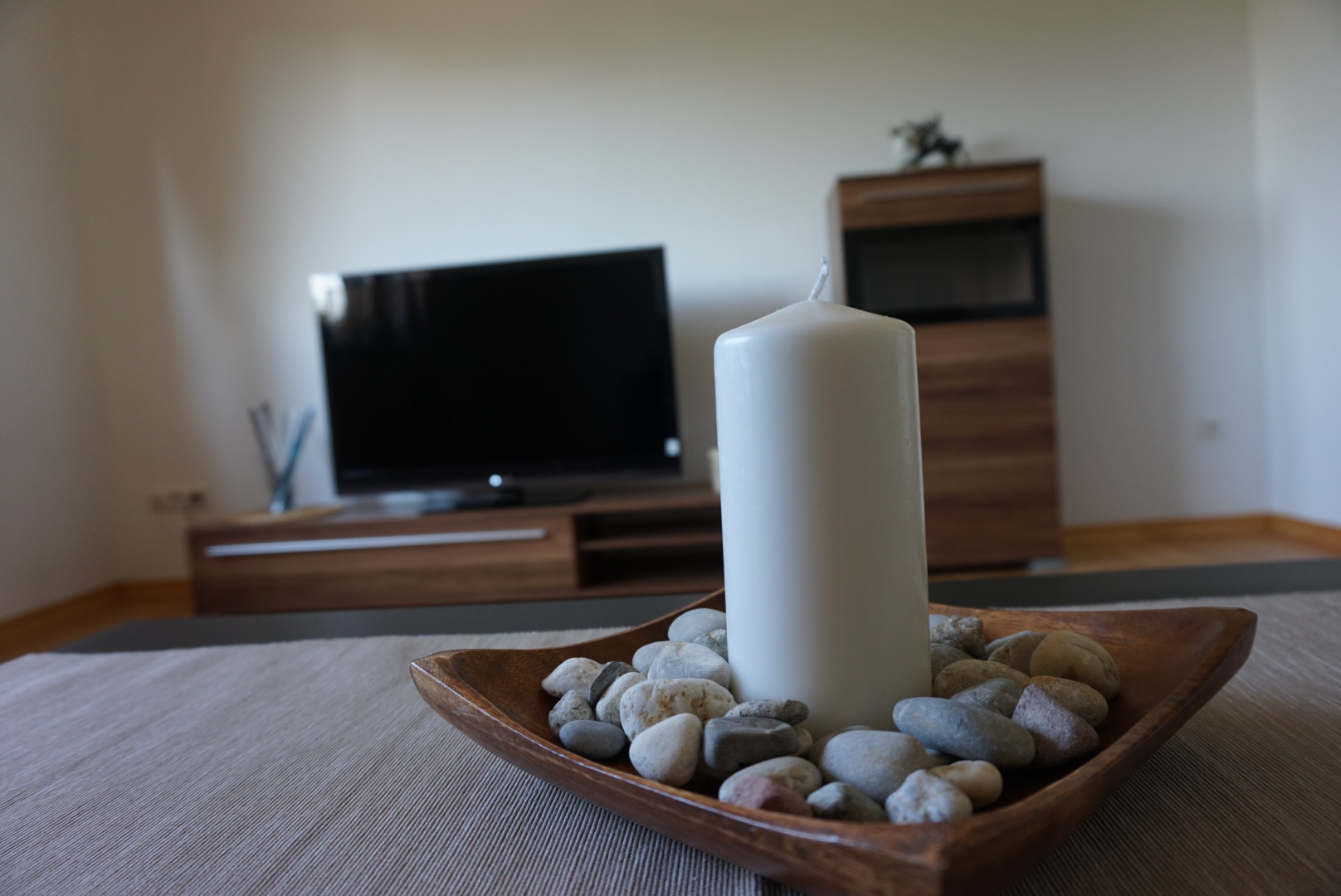 Wohnbereich mit Fernseher und Kerzendekoration auf dem Tisch