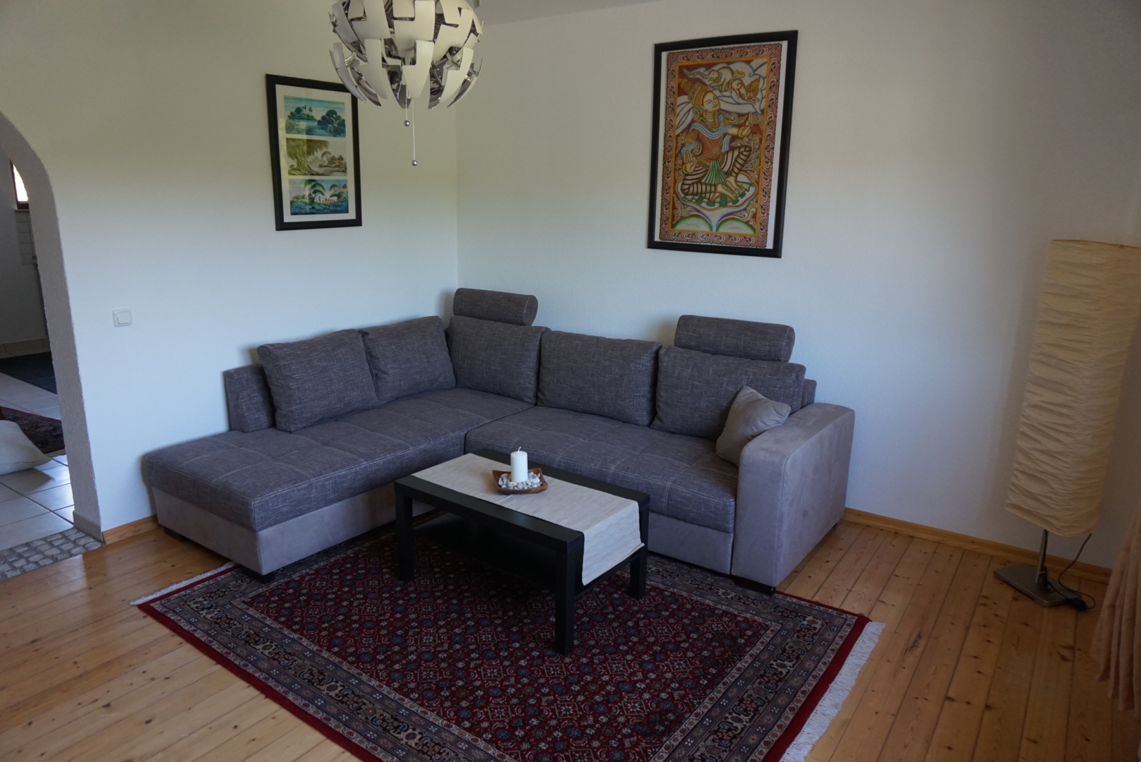 Wohnzimmer mit grauer Schlafcouch und Couchtisch
