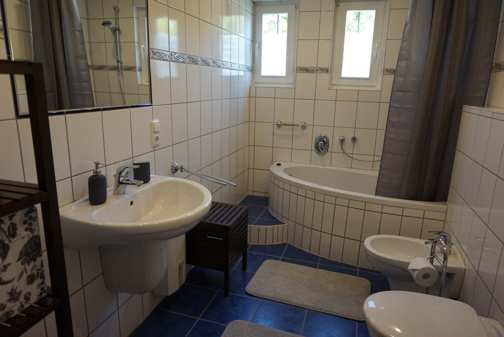 Badezimmer mit Badewanne, Waschbecken und Fenster